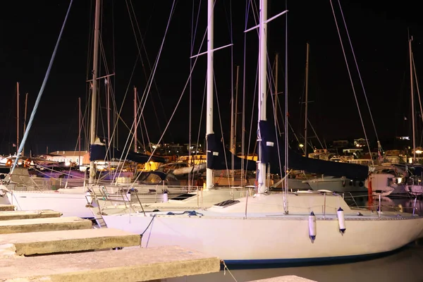 Night parking of yachts in the Croatian ACI marina of the town of Jazira. Burning lights of the evening Mediterranean port with sailing yachts and fishing boats. Twilight on the Adriatic Riviera. Calm