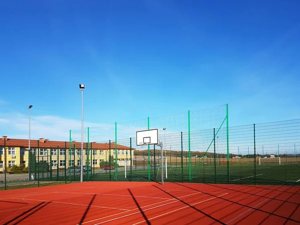 Lubno, Polônia - 9 de julho de 2018: Um estádio aberto no pátio de uma escola de aldeia. Educação da geração mais jovem. Campo de esportes para futebol, voleibol e basquete. Iluminação em fontes naturais — Fotografia de Stock