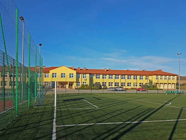 Lubno, Polônia - 9 de julho de 2018: Um estádio aberto no pátio de uma escola de aldeia. Educação da geração mais jovem. Campo de esportes para futebol, voleibol e basquete. Iluminação em fontes naturais — Fotografia de Stock