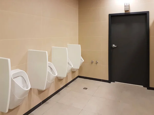 Badausstattung in hellen beigen und weißen Farben. ovales keramisches Urinal. Ort der Not für Männer. Toilette in öffentlichen Bereichen der städtischen Infrastruktur. Innenraum des öffentlichen Raums — Stockfoto