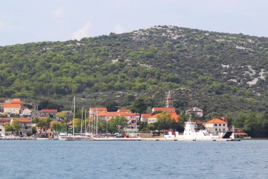 Beyaz feribot şehir Zadar yakınındaki Adası Pasman üzerinde Mrljiane Hırvat marinada demirlemiş. Antik şehir, Dalmaçya Adriyatik Denizi'nde antik mimariye sahip. Akdeniz Bölgesi