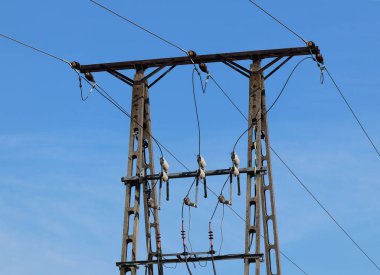 Fırtınalı bir gökyüzü, bulutlar çerçevede bir güneş tarafından aydınlatılmış bir yüksek voltajlı güç hattı. Enerji uzun mesafelere taşınması. Modernliğin yüksek teknoloji. Güç endüstrisi. Ekoloji