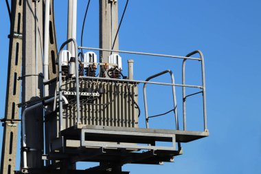 Fırtınalı bir gökyüzü, bulutlar çerçevede bir güneş tarafından aydınlatılmış bir yüksek voltajlı güç transformatörü. Enerji uzun mesafelere taşınması. Modernliğin yüksek teknoloji. Güç endüstrisi. Ekoloji