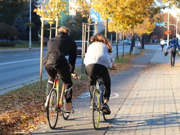 Ein junges Paar, ein Junge und ein Mädchen, fahren tagsüber mit dem Fahrrad auf dem Weg durch die herbstliche Guliza. Aktives Leben entspannen. Ökologischer Verkehr. Umweltschutz in einer europäischen Stadt — Stockfoto