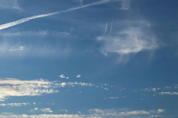 Cirrus clouds on a clear blue sky. Weather forecast. Water in a gaseous state in nature. The atmosphere of the earth. The effect of humidity on agricultural production. The symbol of freedom