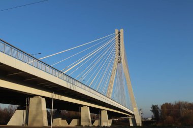 Rzeszow, Polonya - 99 2018: Wislok Nehri üzerindeki askıya alınmış yol köprüsü. Metal inşaat teknolojik yapısı. Modern mimari. Mavi arka planda beyaz bir haç şehrin bir sembolüdür.