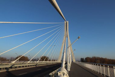 Rzeszow, Polonya - 99 2018: Wislok Nehri üzerindeki askıya alınmış yol köprüsü. Metal inşaat teknolojik yapısı. Modern mimari. Mavi arka planda beyaz bir haç şehrin bir sembolüdür.