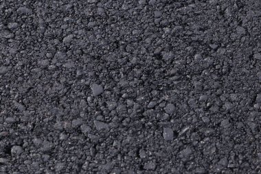 Koyu siyah arka plan haddelenmiş asfalt keşfedemiyoruz. Araçlar ve yayalar için katı kaplama modern teknolojiler. Otoyol İnşaatı unsurları. Fındıktan küçük taneli yapısı