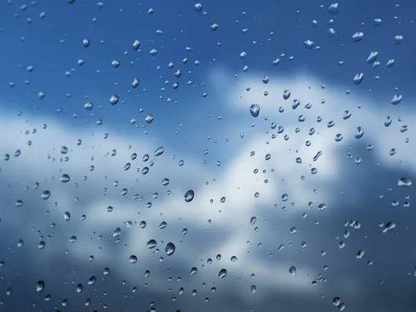 Gotas de chuva no vidro contra o céu azul com nuvem.Céu azul claro com cumulus e nuvens cirrus. Tempo ensolarado. Humor alegre. Alta pressão. Ecologia do ar limpo. Água em estado gasoso — Fotografia de Stock