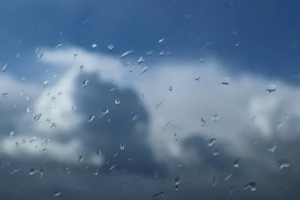 Gotas de chuva no vidro contra o céu azul com nuvem.Céu azul claro com cumulus e nuvens cirrus. Tempo ensolarado. Humor alegre. Alta pressão. Ecologia do ar limpo. Água em estado gasoso — Fotografia de Stock