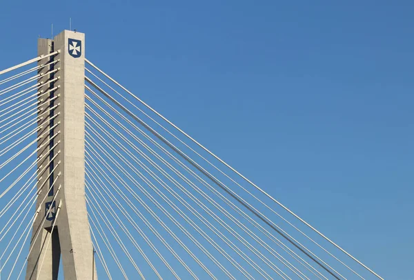 Rzeszow, Pologne - 9 9 2018 : Pont routier suspendu traversant la rivière Wislok. Construction métallique structure technologique. Architecture moderne. Une croix blanche sur fond bleu est un symbole de la ville — Photo