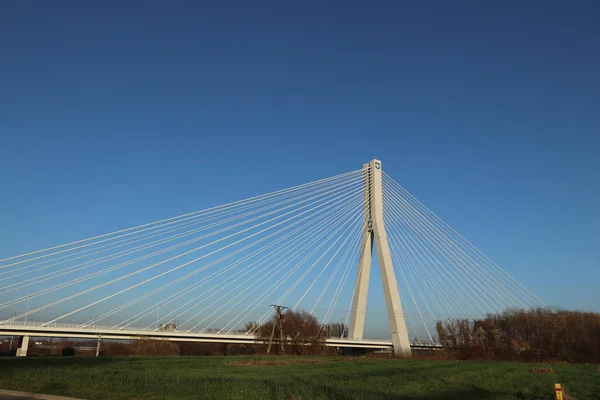 Rzeszow, Polonia - 9 9 2018: Puente colgante sobre el río Wislok. Estructura tecnológica de construcción metálica. Arquitectura moderna. Una cruz blanca sobre un fondo azul es un símbolo de la ciudad — Foto de Stock