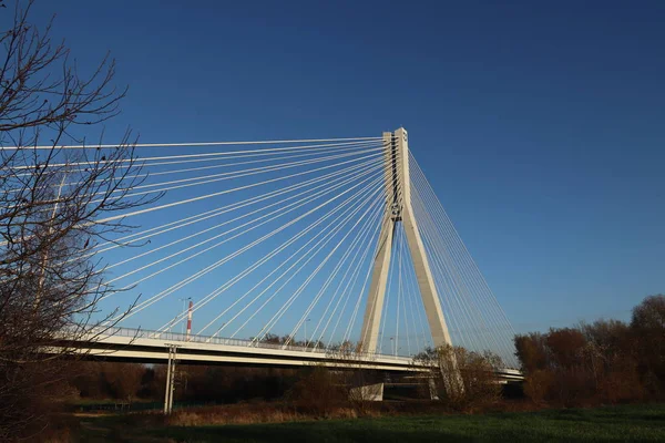 Rzeszow, Πολωνία - 9 9 2018: Αναστολή οδικής γέφυρας στον ποταμό Wislok. Τεχνολογική δομή μεταλλικών κατασκευών. Μοντέρνα αρχιτεκτονική. Ένας λευκός σταυρός σε μπλε φόντο είναι σύμβολο της πόλης. — Φωτογραφία Αρχείου