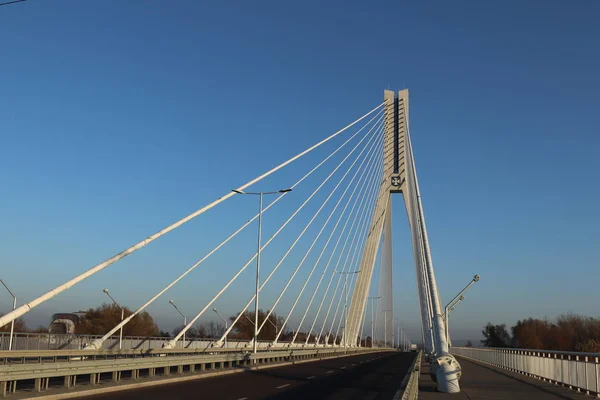 Rzeszów, Polska - 9 9 9 2018: Zawieszony most drogowy przez Wisłok. Metalowa konstrukcja technologiczna. Nowoczesna architektura. Biały krzyż na niebieskim tle jest symbolem miasta — Zdjęcie stockowe