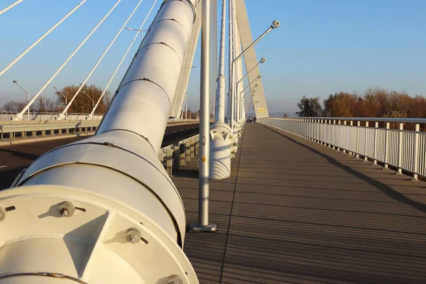 Rzeszow, Poland - 9 9 9 2018: Suspended road bridge across the Wislok River. Технологическая структура металлоконструкции. Современная архитектура. Белый крест на синем фоне - символ города — стоковое фото