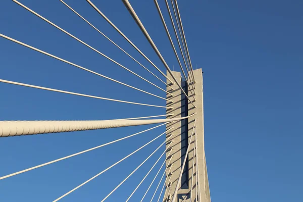 Rzeszow, Pologne - 9 9 2018 : Pont routier suspendu traversant la rivière Wislok. Construction métallique structure technologique. Architecture moderne. Une croix blanche sur fond bleu est un symbole de la ville — Photo