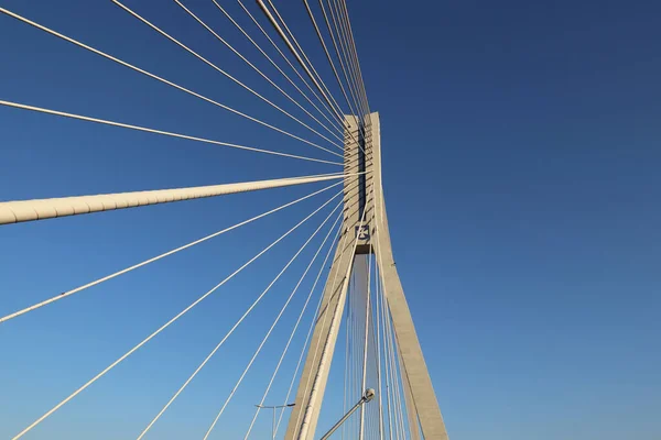 Rzeszow, Pologne - 9 9 2018 : Pont routier suspendu traversant la rivière Wislok. Construction métallique structure technologique. Architecture moderne. Une croix blanche sur fond bleu est un symbole de la ville — Photo