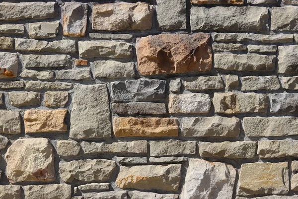 Ancient medieval stone masonry. Texture of a fragment of a wall of an old structure. A background for design and creative work. Decoration and exterior decoration of the building. Construction works