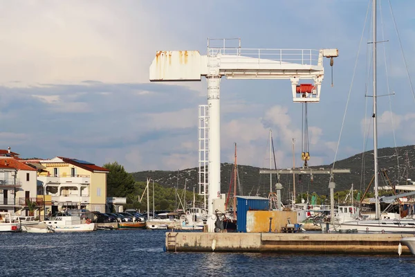 Крана підняти для підвищення човна в marina Aci Jazera в Хорватії. Далматинська ragion Адріатичного моря в Середземному морі. Кораблі, що курсують в порту тихий рибальське село в Сонячний, ясний день — стокове фото