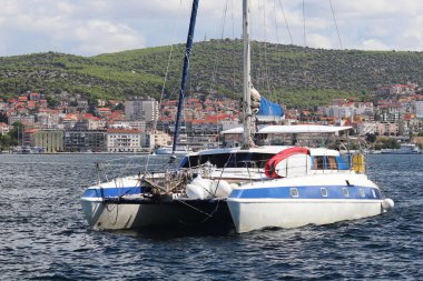 Kırmızı edebi işaret - fairway deniz feneri geçmişte kayalık yeşil kıyı boyunca yelkenli katamaran yelken. Şehir Sibenik Hırvatistan'daki Dalmaçya bölgesindeki. Adriyatik Denizi Akdeniz bölgesinde