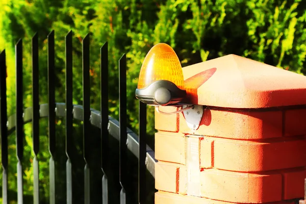 Oranje kamer alarm licht ligt op een baksteen fence post. Het appartementengebouw van de intercom bij de ingang een beschermde privéruimte. Risico waarschuwing. Intercom voor deurplaat. Bescherming van eigendom en uitgevoerd met Securit — Stockfoto