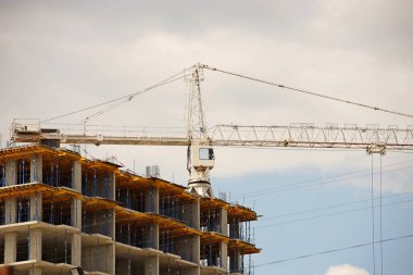 Kule vinçleri çok katlı bir binanın yapımı sırasında çalışır. Apartman sakinleri için yeni daireler ve ofisler için binalar. Yüksekken riskli iş. Ağır inşaat malzemeleri kaldırılıyor. Şehir Geliştirme