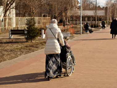 Gardiyan, tekerlekli sandalyedeki yaşlı ve zayıf bir adamı taşıyor. Güneşli bir günde gezinti güvertesi boyunca temiz havada yürüyün. Emeklilerle ve bakıma ihtiyacı olan insanlarla ilgilenmek. Ömür boyu ilaç. Neşeli ve aktif.