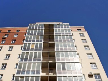 Lviv, Ukrayna - 342020: Balkonları ve büyük cam pencereleri olan çok katlı modern bir evin cephesi. Modern mimari tasarımı. Alttan üstten bak. Modern şehir mimarisi