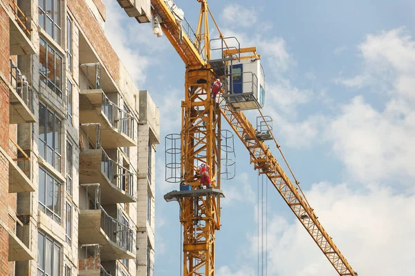 塔式起重机在一座多层建筑的施工过程中工作 新的居民公寓和办公房地 高风险的工作在高处 吊起重型建筑材料 城市发展 — 图库照片