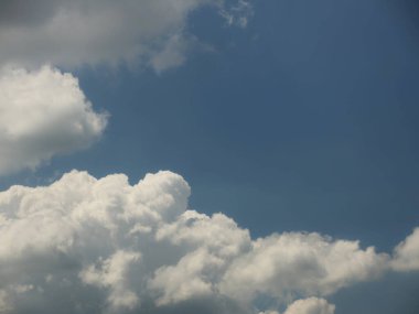 Kümülüs ve sirrus bulutlarıyla açık mavi gökyüzü. Güneşli bir hava. Neşeli bir ruh hali. Yüksek basınç. Temiz hava ekolojisi. Gaz halindeki bir su. Yağmur ve dolu kaynağı. Hava tahminleri.