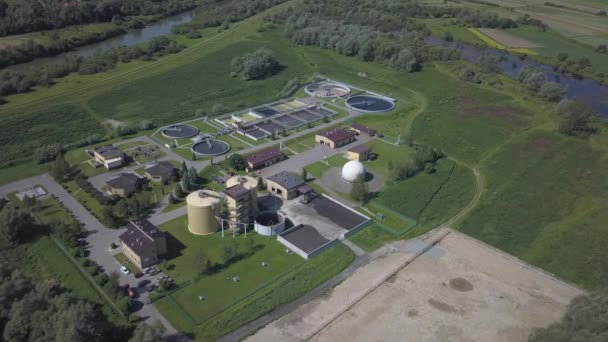 Station de traitement des eaux usées urbaines. Photographie aérienne d'usines de traitement des eaux usées situées dans un beau terrain vallonné verdoyant. Recyclage des déchets humains. La question de l'eau potable — Video