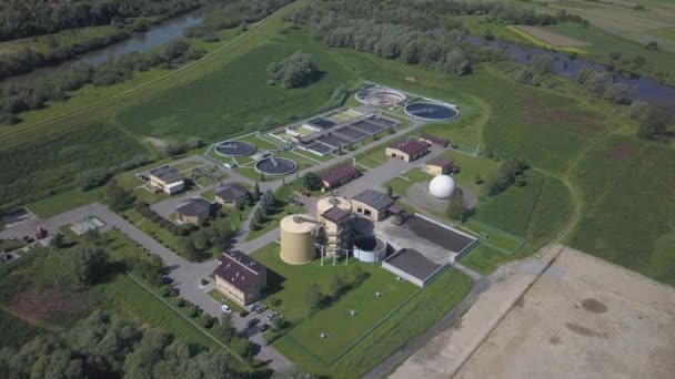 Station de traitement des eaux usées urbaines. Photographie aérienne d'usines de traitement des eaux usées situées dans un beau terrain vallonné verdoyant. Recyclage des déchets humains. La question de l'eau potable — Video