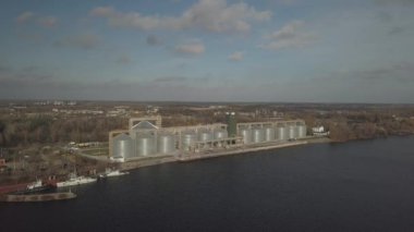 Nehir kıyısındaki limanda tahıl asansörü. Ekinleri depolamak için devasa paslanmaz çelik tanklar. Hava aracı ya da kuadrokopter hava görüntüsü. Tarım endüstrisi. Tarım. Ukrayna 'da modern çiftlik.