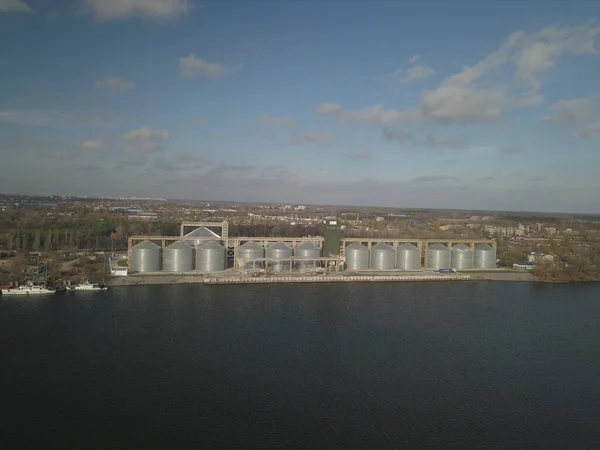 Ascenseur à grain dans le port sur la rive du fleuve. Grands réservoirs en acier inoxydable pour le stockage des cultures. Drone aérien ou quadrocopter vue aérienne. Secteur agro-industriel. L'agriculture. Ferme moderne en Ukraine — Photo