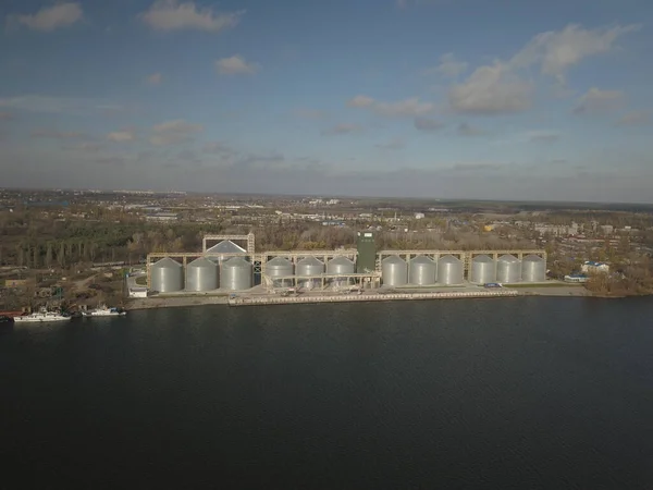 川岸の港の穀物エレベーター 作物を保存するための巨大なステンレス製タンク 空中ドローンや四面体の空中ビュー 工業事業 ウクライナの近代的な農場 — ストック写真