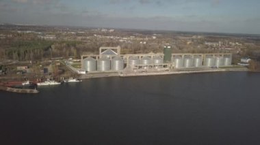 Nehir kıyısındaki limanda tahıl asansörü. Ekinleri depolamak için devasa paslanmaz çelik tanklar. Hava aracı ya da kuadrokopter hava görüntüsü. Tarım endüstrisi. Tarım. Ukrayna 'da modern çiftlik.