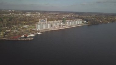 Nehir kıyısındaki limanda tahıl asansörü. Ekinleri depolamak için devasa paslanmaz çelik tanklar. Hava aracı ya da kuadrokopter hava görüntüsü. Tarım endüstrisi. Tarım. Ukrayna 'da modern çiftlik.