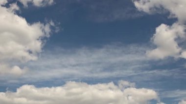 Sabit duran kümülüs bulutlarıyla berrak mavi gökyüzü ve yüzen sirrus bulutları. Neşeli bir ruh hali. Atmosferdeki yüksek basınç ve hareket farkı. Temiz hava ekolojisi. Hava tahminleri