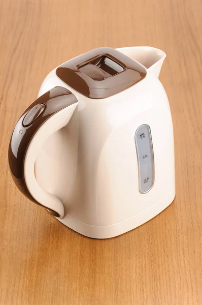 Beige plastic kettle on the wood background — Stock Photo, Image