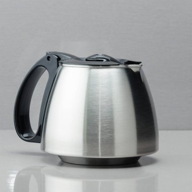 Gri aynalı arka planda siyah kapaklı kahve demliği..