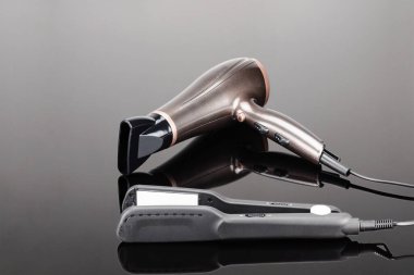 Gri ayna arka planda gri saç demiri ve kahverengi kurutucu