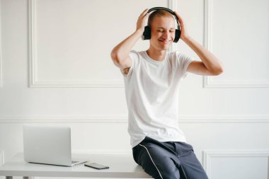 Telsiz kulaklıklı, müzik dinleyen genç bir adamın portresi.