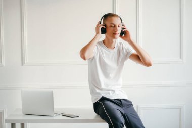 Telsiz kulaklıklı, müzik dinleyen genç bir adamın portresi.