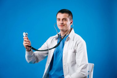 Genç tıp doktoru kalp muayenesi için steteskop kullanıyor.