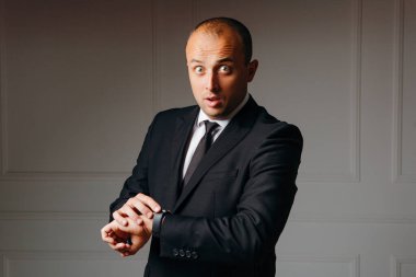 Gülen işadamı beyaz arka planı kontrol ediyor.