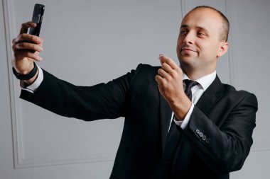 Mutlu iş adamı evlilik yüzüğüyle selfie çekiyor.