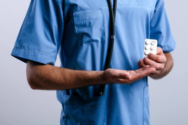 Stajyer doktorun elleri beyaza izole edilmiş hapları açıyor.