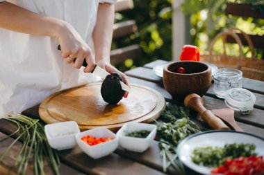 Avokadoyu ikiye bölen kadın elleri. İki avokado yarım guacamole yapmak için hazır