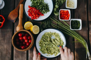 Avokadoyu çatalla ezen kadın elleri, guacamole pişiriyor. Piknik yaz yemekleri.