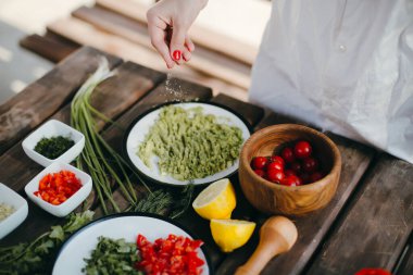 Avokado geçmişine tuz ekleyen kadın elleri, guacamole pişiriyor. Piknik yaz yemekleri.